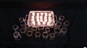 Hand-painted jamjars and lighted candles on black cloth in church